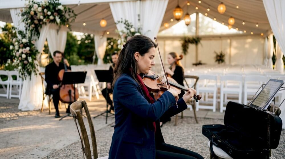 Violinist tuning at outdoor wedding venue