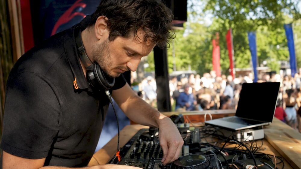 DJ setting up equipment at stadium booth