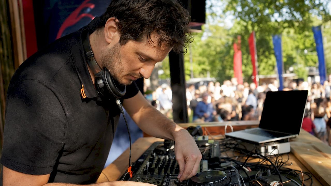 DJ setting up equipment at stadium booth